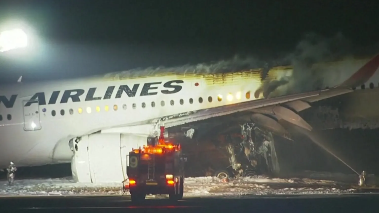 Japan airlines plane on fire on runway at tokyo s haneda airport tv images