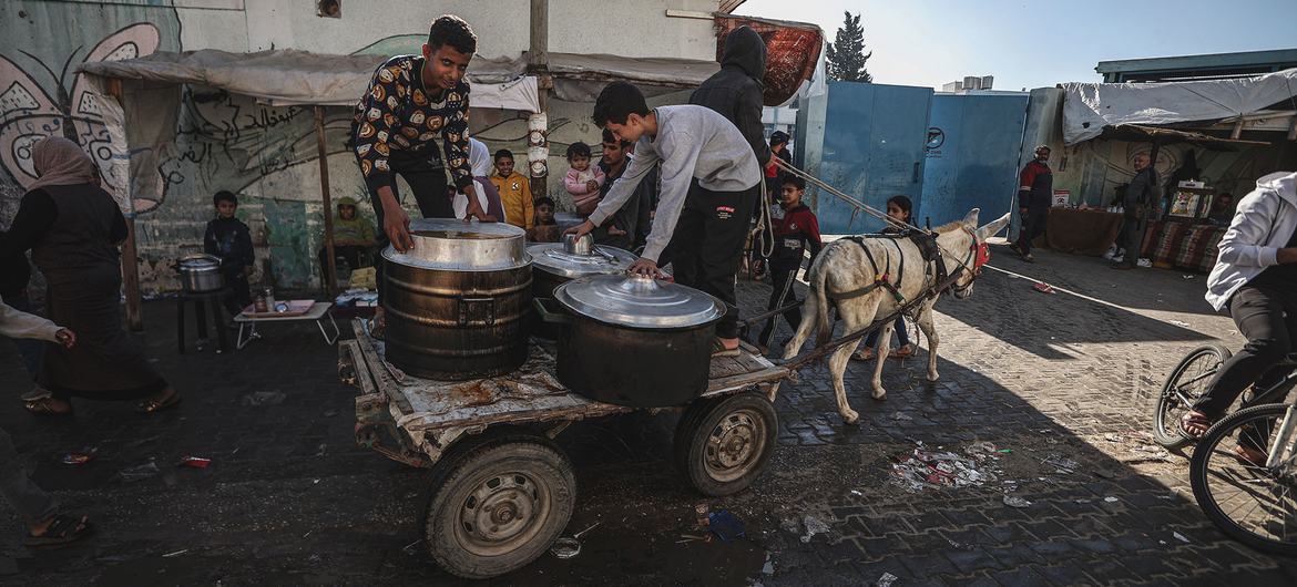 Gazans rush towards aid trucks carrying flour and canned food in gaza city