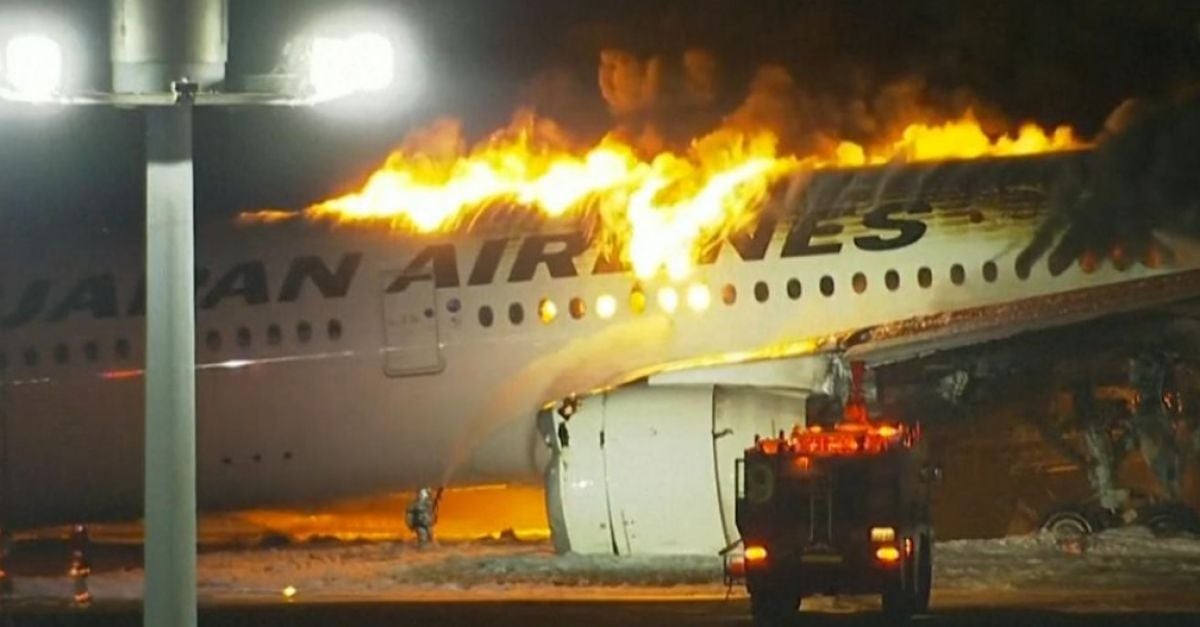 Japan airlines plane on fire on runway at tokyo s haneda airport tv images